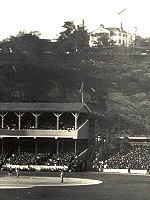 Black-and-white image of the Polo Grounds baseball stadium, with the Morris-Jumel Mansion on a hill in the background