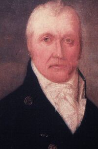 Portrait of the head of man wearing black coat and a white scarf around his neck.