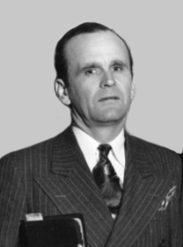 A middle aged man wearing a pinstripe suit with a tie