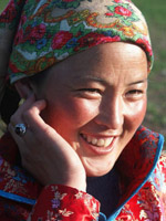 A smiling Daur woman in traditional attire