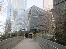 A pathway with handrails, with a short opaque building in the center