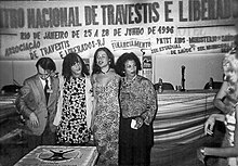4 activists underneath a sign advertising the 1996 ENTLAIDS.