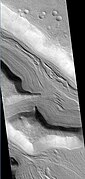 Hypsas Valles, as seen by HiRISE. Ridges are probably due to glacial flow. So water ice is under a thin layer of rocks.