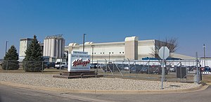 A color photograph of a manufacturing building with a sign that says "Kellogg's" in front