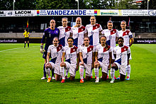 Eleven women in football kit posing for a group photo