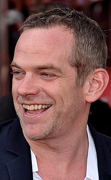 close-up of Garou grinning and looking left of camera