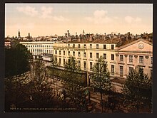 Tinted postcard of long white building