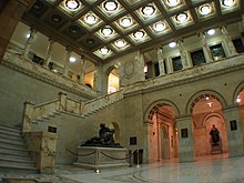 Marble lobby with statues, columns and a flight of steps