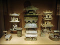Among a large set of architectural models, three Eastern Han dynasty watchtowers stand in the rear of this display.