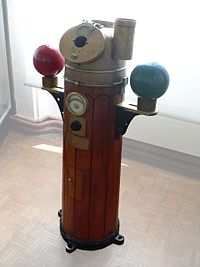 Binnacle with iron correcting spheres at each side and clinometer below compass