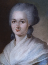 Portrait of a woman, showing her head, with a grey wig. Two large curls are sitting at the nape of her neck. Her shoulders are covered with a filmy, cream-coloured shawl.