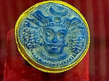 A golden ring showing a Sasanian king with a crescent moon crown and stepped crenellations