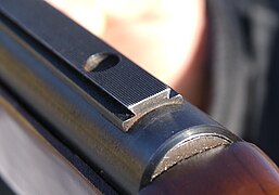 A dovetail rail on a rifle receiver for mounting sights with a drilling on top for an additional shape connection.