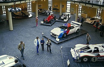 Ausreichend Platz für Fahrzeuge und Be­sucher, rechts Porsche 956, in der Mitte BMW M1, dahinter Alfa Romeo Tipo 159 und Porsche F1-804