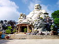 Statue of Maitreya in Budai form surrounded by a dragon on Cấm Mountains, Vietnam