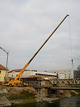 Truck mounted crane building a bridge