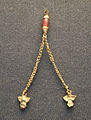Gold ornament with two chains ending in owl figurines
