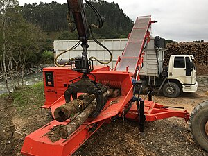 Tree chipper mounted by side to tree processing into biomass for energetic burning