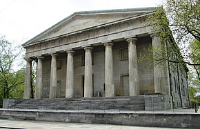 An old stone building with pillars. Classical Greek style architecture.