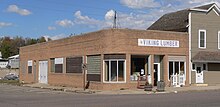 One-story brick building with rounded corners, probably dating from the 1940s or early 1950s; "Viking Lumber" sign with profile head of Viking