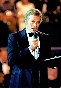 Photograph of Charlton Heston in a suit addressing guests