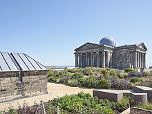Restored City Observatory, which opened as Collective, centre for contemporary art, in 2018. Observatory building and Transit House shown with colourful flowerbeds in foreground.