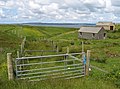 Garrabost on the north coast of the Eye Peninsula, Isle of Lewis, Outer Hebrides (2007). Image shows complicated fencing patterns necessary on crofting land; modern or modernised buildings in traditional design.