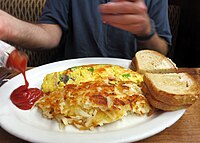 A Denver omelette with toast, hash browns and tomato ketchup