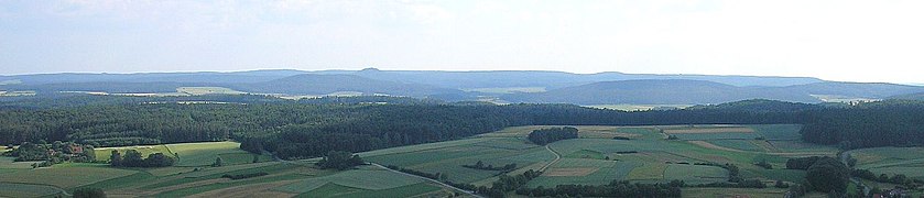 The rolling hills of the Haßberge from the eastern hillside of the Zeilberge near Maroldsweisach. Centre left: the prominent volcanic cone of the Bramberg