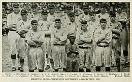 Seventeen baseball players wearing light uniforms with dark vertical pinstripes standing with their arms crossed.