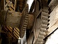 Inside threshing barn: gear wheels on end of drive shaft, where further gears and drive belts would be attached for driving various machines
