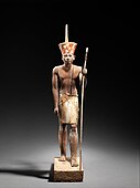 A guardian statue which reflects the facial features of the reigning king, probably Amenemhat I or Senwosret I, and which functioned as a divine guardian for the imiut. Made of cedar wood and plaster c. 1919–1885 BC[27]