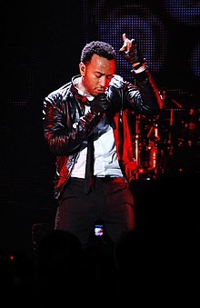 John Legend performing in a dark jacket, white shirt and black pants