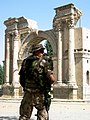 An ISAF soldier standing by the ruins of the Victory Arch in 2004, before its renovation