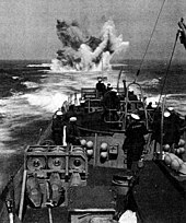 A depth charge explodes astern during a practice anti-submarine run during the ship's shakedown tests.