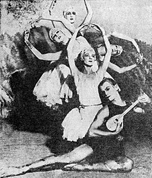 Five dancers posing in front of a forested backdrop