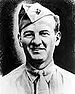 Head of a half-smiling white man wearing a shirt and tie and a garrison cap tilted over his right ear.
