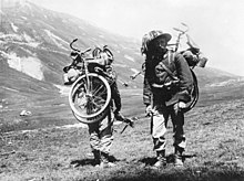 B&W photo of two soldiers with bikes
