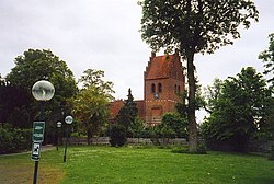 A redbrick church surrounded by trees
