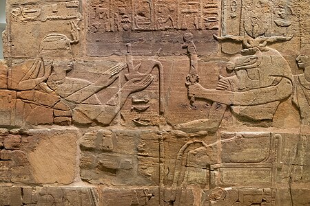 Sandstone wall of King Aspelta offering Ma'at (Truth) to ram-headed god Amun-Re accompanied by Anukis, Temple T at Kawa. Ashmolean Museum I9J2.I295.[23]