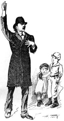 A man in a hat recites with his hand raised upwards. Two children watch.