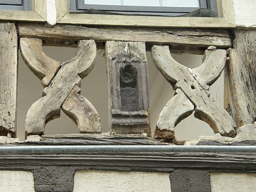 Andreaskreuze in der geschweiften Form neben einer Heiligennische im Holzbalken, Gefache fehlen
