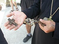 A man holding several Eastern Orthodox pectoral crosses