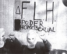 Two hooded FLH members posing and holding a sign