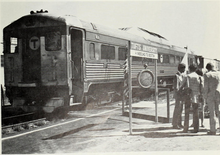 A diesel railcar next to a small platform