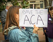 Woman holding sign that says "Save the ACA", at a rally in Washington D.C..