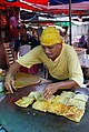 Image 48Murtabak being made at a stall, a type of pancake filled with eggs, small chunks of meat and onions. (from Malaysian cuisine)