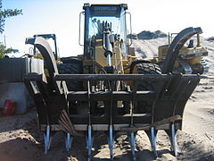 The front of a Caterpillar 930G fitted with loader rake.