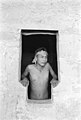 Emmett Harryson, a Navajo, at a T-shaped doorway at Balcony House (1929)