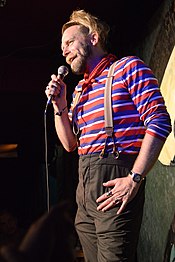 man in striped shirt holding microphone